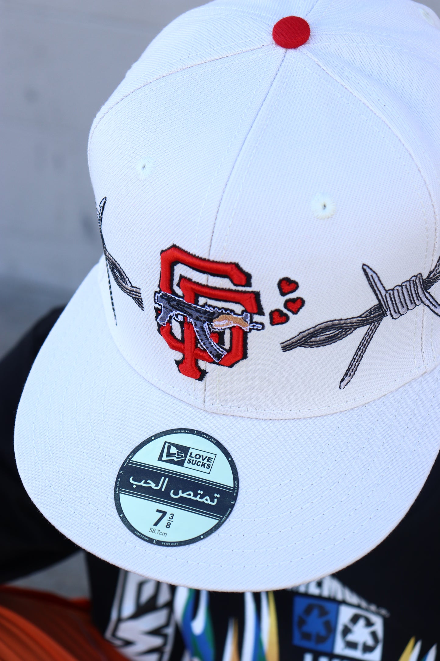 LOVE SUCKS BARBWIRE FITTED CAP in CREAM/RED